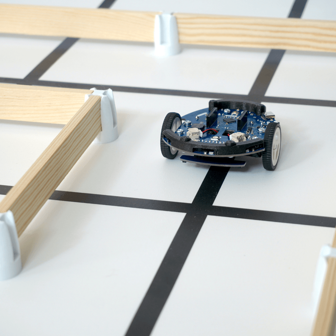 Un Eliobot Maker sans coque suit une ligne noire sur un tapis blanc