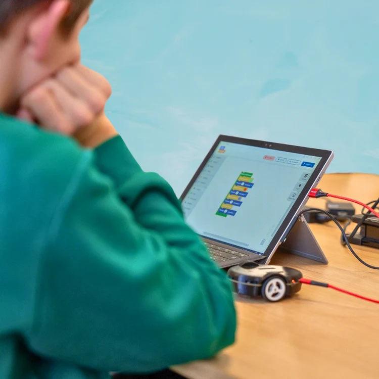 Un enfant programme son Eliobot sur une tablette