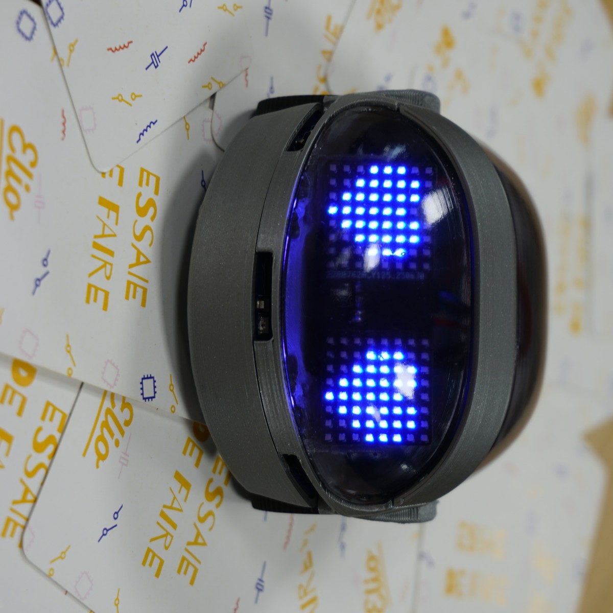 Gros plan sur les yeux LED de l'Eliobot, allumés en bleu
